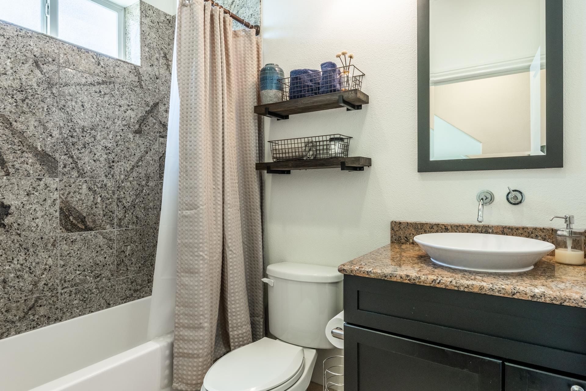 1787 Old Mammoth Road, Unit 2 Mammoth Lakes, CA 93546 - Photo 11 of 29 Bathroom featuring a vessel sink, brown speckled countertop, black vanity, and a shower with pattern