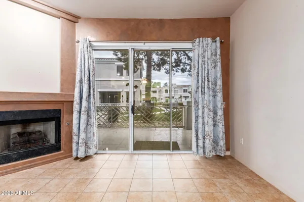 an empty room with fireplace fan and windows