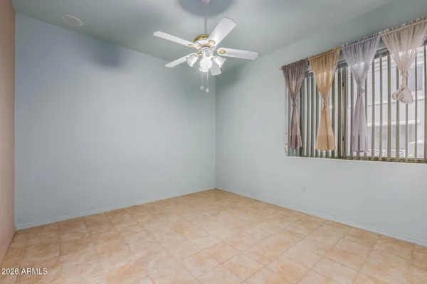 an empty room with fan and entrance