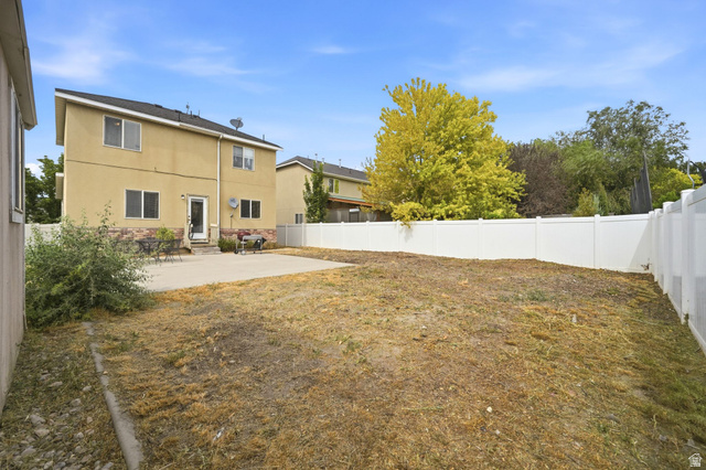 297 West Bricker Road Draper, UT 84020 - Photo 33 of 44 Expansive backyard featuring a concrete patio, a tall privacy fence, and mature trees in the background