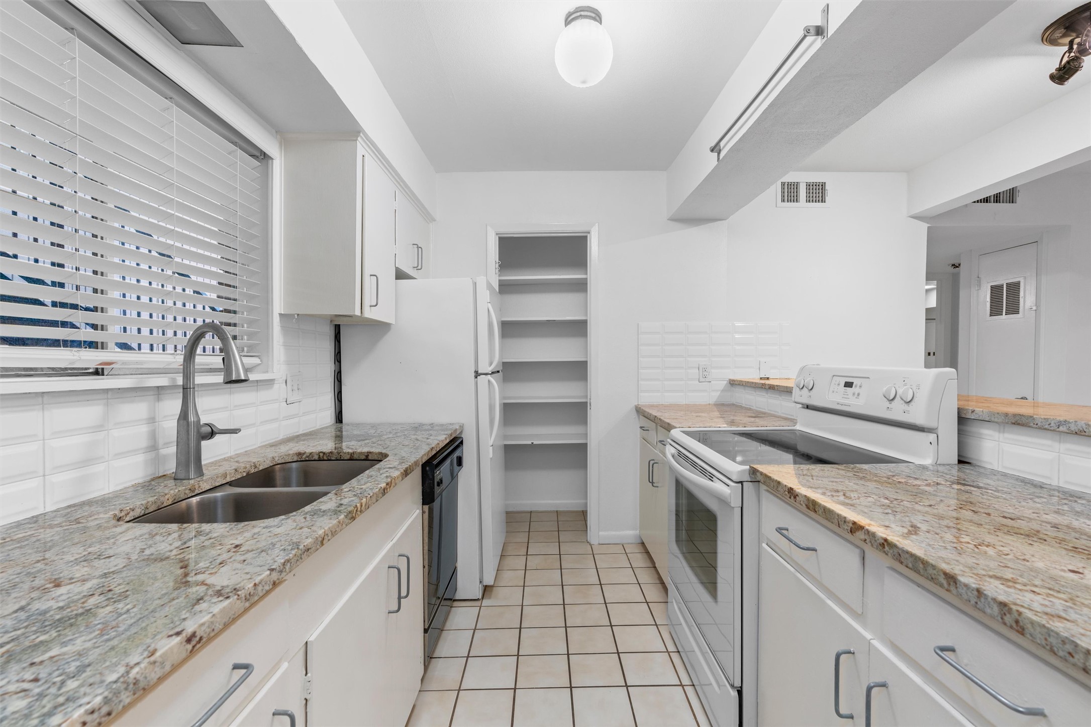 2208 Enfield Road, Unit 10500 Austin, TX 78703 - Photo 15 of 34 Kitchen featuring white cabinetry, stone-finish countertops, subway tile backsplash, and built-in shelving