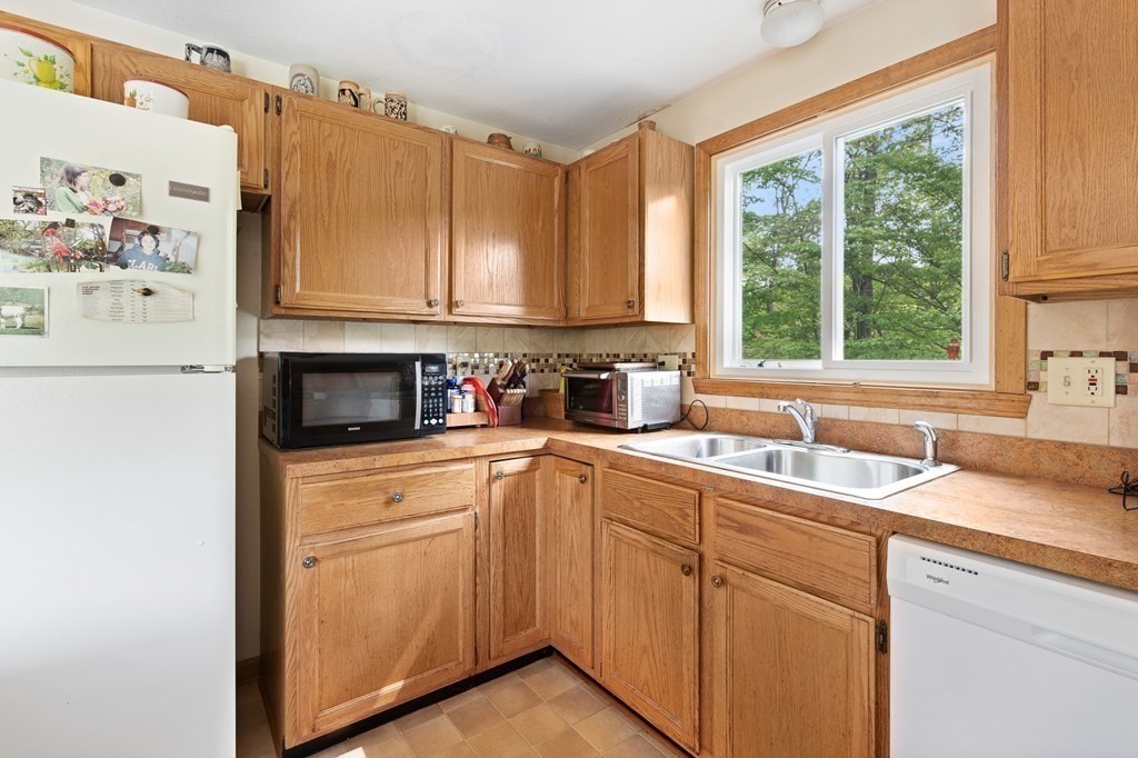 32 Middle Road Southampton, MA 01073 - Photo 16 of 39 a kitchen with stainless steel appliances granite countertop a sink a stove and white cabinets