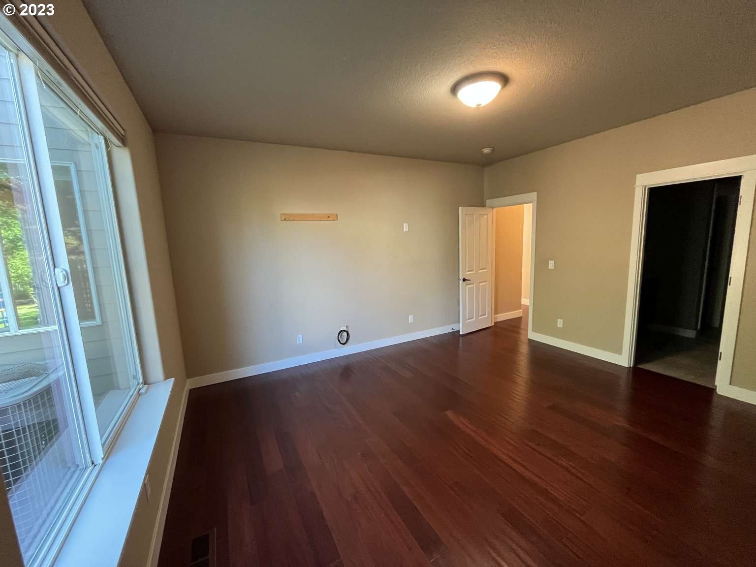 199 Northwest Camp Ireland Street Hillsboro, OR 97124 - Photo 7 of 36 a view of an empty room with wooden floor and a window