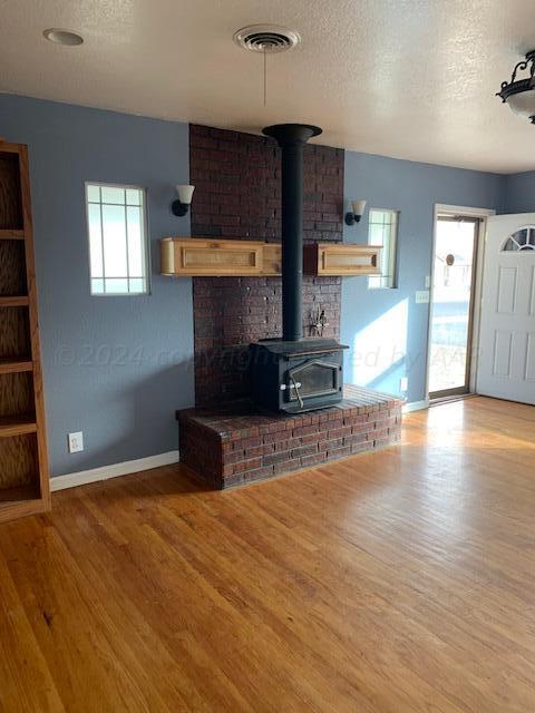 a kitchen with stainless steel appliances wooden floor and a refrigerator