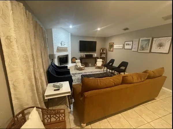 a living room with furniture a flat screen tv and a wall painting