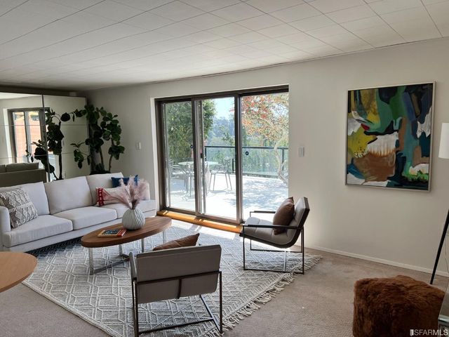 a living room with furniture and a floor to ceiling window