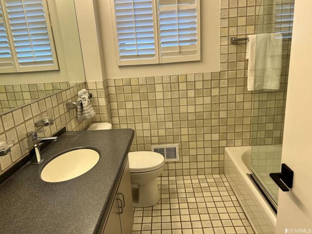 a bathroom with a sink a toilet a mirror and shower