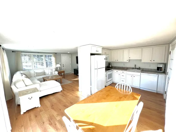 a living room with stainless steel appliances kitchen island granite countertop a couch and a view of living room