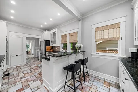 a kitchen with granite countertop a stove a sink and a refrigerator