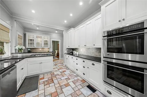 a large kitchen with granite countertop a stove top oven microwave and cabinets