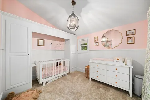 a bedroom with a baby bed and a window