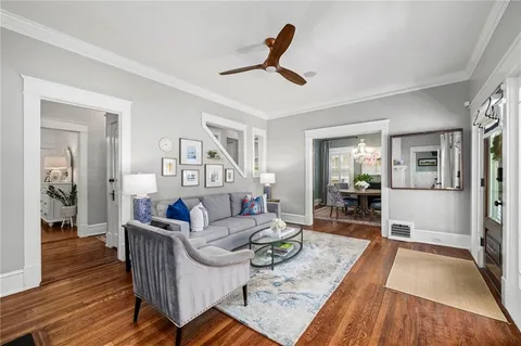 a living room with furniture and a wooden floor