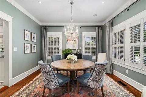 a dining room with furniture a chandelier and wooden floor