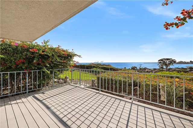 a view of a balcony with wooden floor and fence