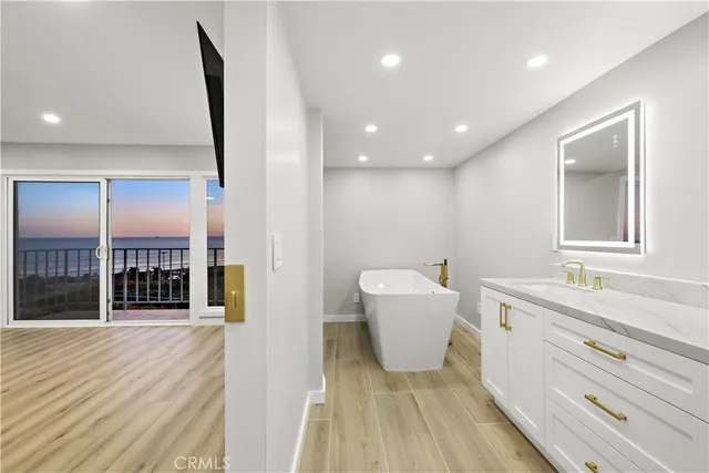 a bathroom with a double vanity sink mirror and bathtub