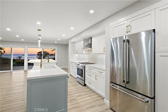 a kitchen with stainless steel appliances a refrigerator sink and stove