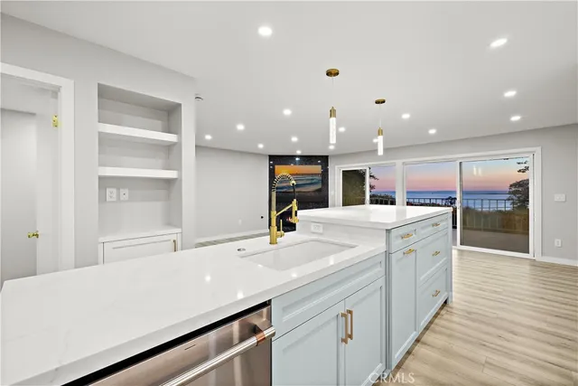 a kitchen with kitchen island a sink and a stove with wooden floor