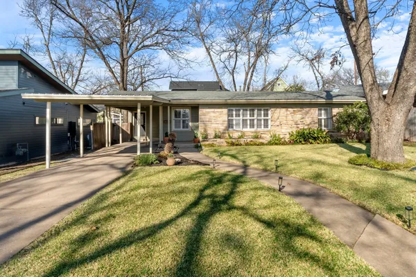 a view of a house with backyard and a tree