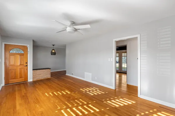 a view of empty room with wooden floor