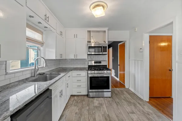 a kitchen with stainless steel appliances granite countertop a sink stove and refrigerator