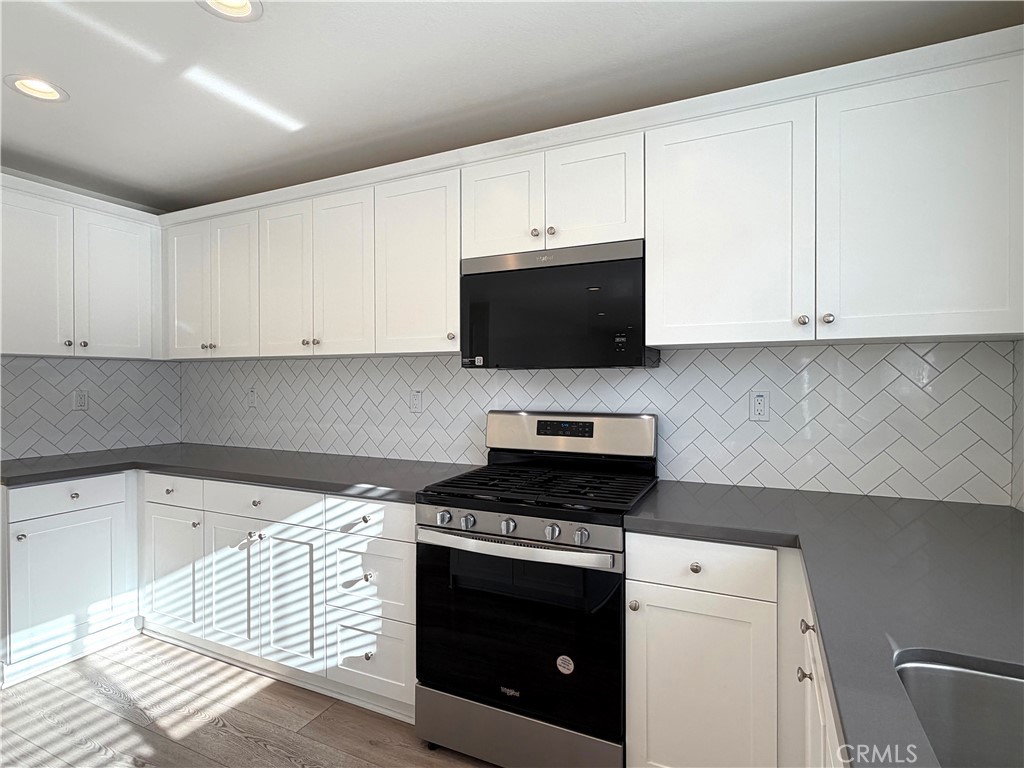 7631 Rubyred Gln Drive Riverside, CA 92507 - Photo 2 of 17 a kitchen with granite countertop white cabinets and stainless steel appliances
