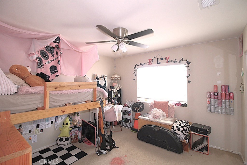 924 Condor Street Barstow, CA 92311 - Photo 26 of 52 a bedroom with a bed and a chandelier