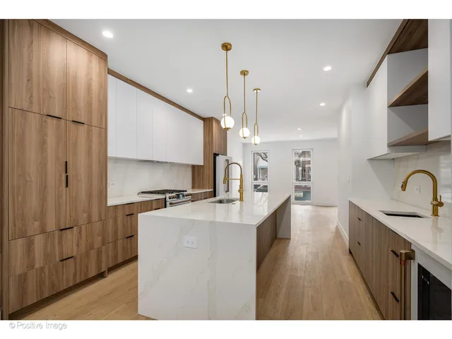 a kitchen with kitchen island a counter top space a sink stainless steel appliances and cabinets