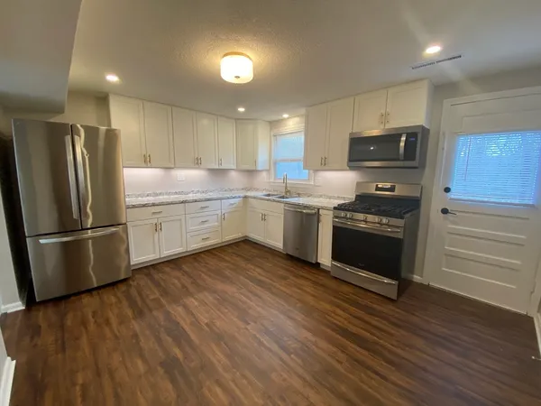 a kitchen with stainless steel appliances a stove a sink and a refrigerator