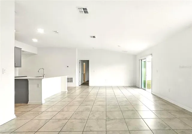 a view of an empty room with a kitchen