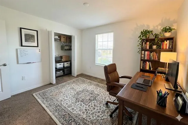 a view of a workspace with furniture and a window