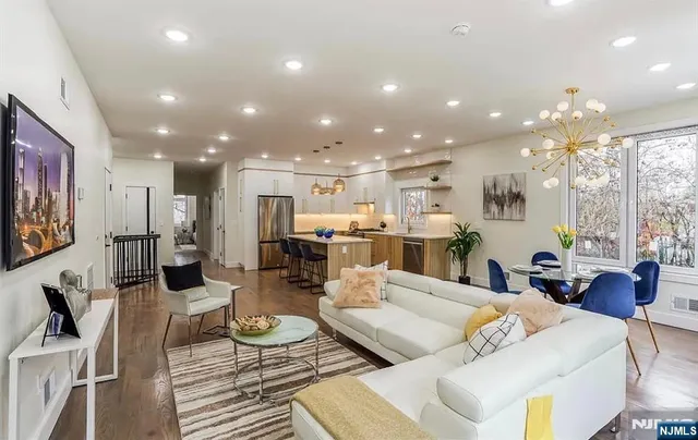 a living room with furniture and a view of kitchen