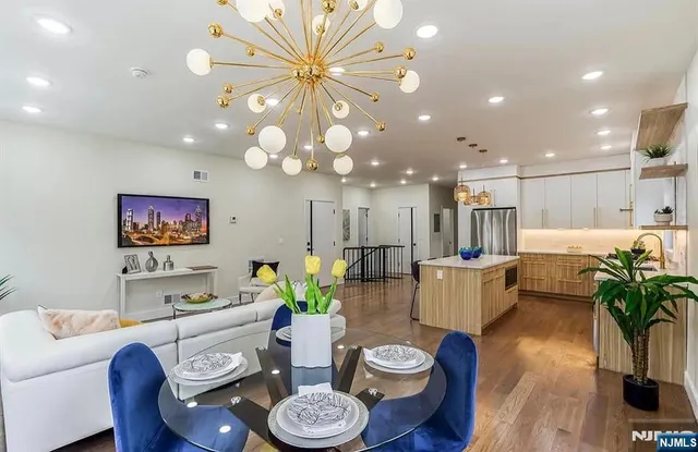 a living room with furniture and a dining table with wooden floor