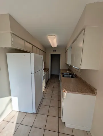 a kitchen with a refrigerator a stove top oven and cabinets