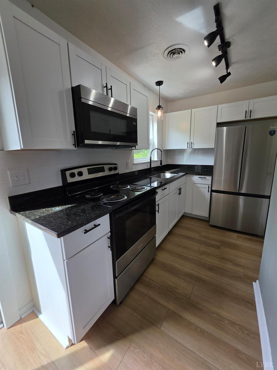 178 Dulwich Drive, Unit 178 Amherst, VA 24521 - Photo 5 of 17 a kitchen with granite countertop a sink and steel appliances