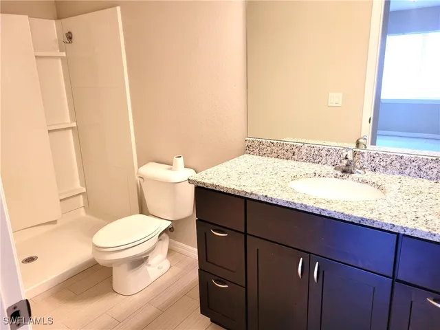 a bathroom with a granite countertop sink toilet and shower