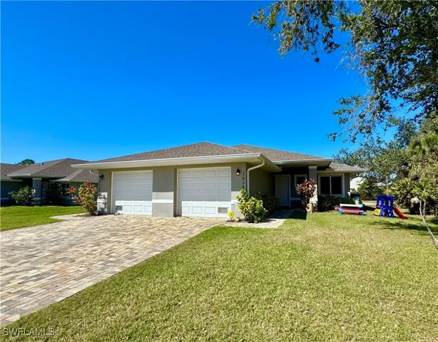 a view of a house with a yard and tree
