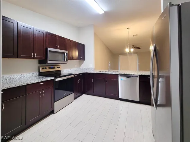 a kitchen with stainless steel appliances a sink and a refrigerator