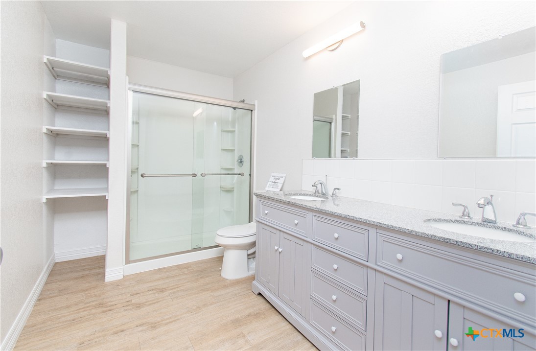 199 Apache Springs Road Briggs, TX 78608 - Photo 17 of 28 a bathroom with a granite countertop sink toilet and shower