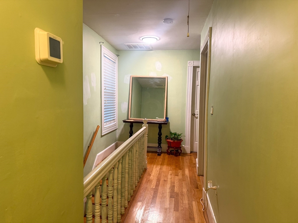 92 Spencer Street Boston, MA 02124 - Photo 20 of 34 a view of a hallway with wooden floor and staircase