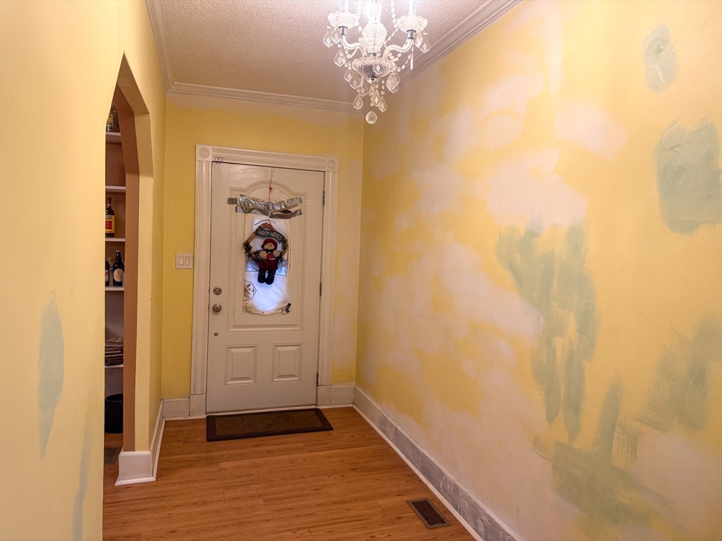 92 Spencer Street Boston, MA 02124 - Photo 10 of 34 a view of a hallway with wooden floor and a chandelier