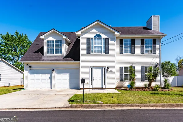 a front view of a house with a yard and garage