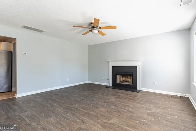 a view of an empty room with a fireplace and window