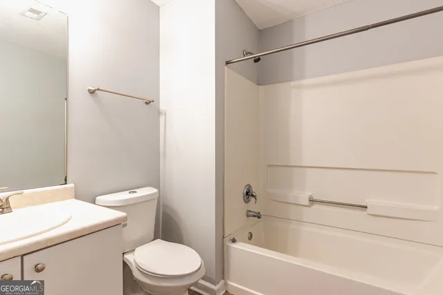 a white toilet sitting next to a bath tub