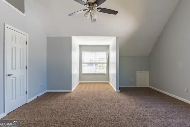 a view of a room with a ceiling fan and window