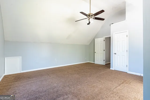an empty room with closet and ceiling fan