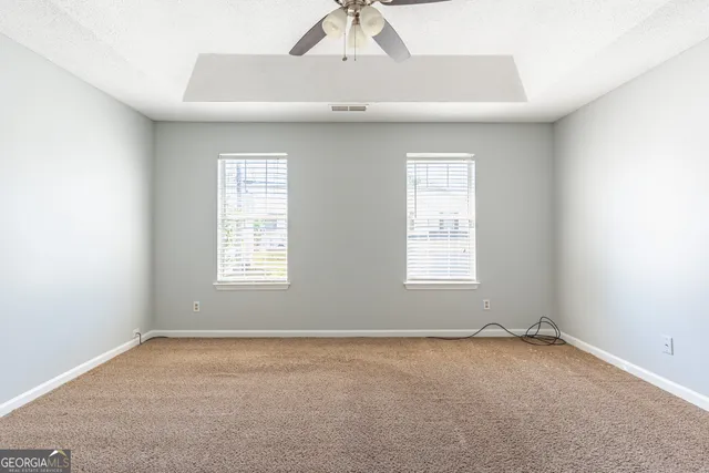 an empty room with a window and a ceiling fan