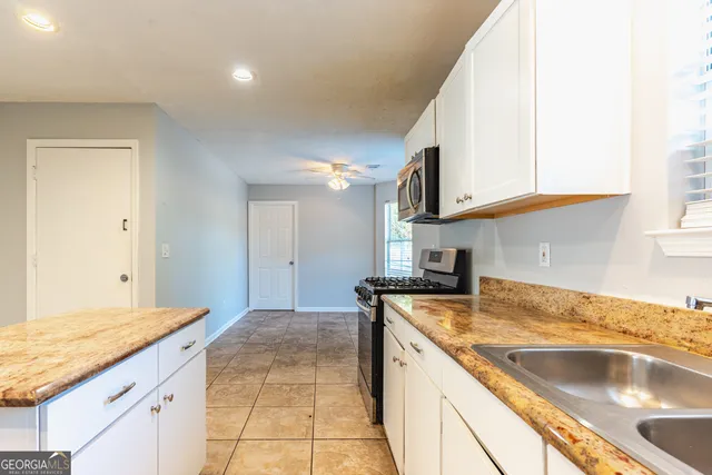 a kitchen with a sink stove and cabinets