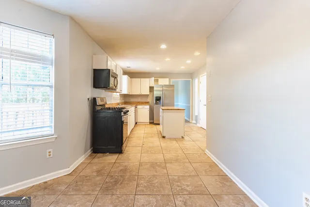 a large kitchen with stainless steel appliances a refrigerator and a stove top oven