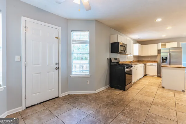 a large kitchen with granite countertop a stove top oven a sink a counter space and cabinets