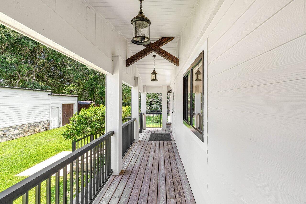 17270 Rocky Pines Road Jupiter, FL 33478 - Photo 18 of 69 a view of a porch with wooden floor in front of house